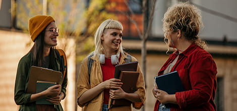 Three medical students talking to each other outside their university